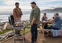 People next to water grilling food and talking