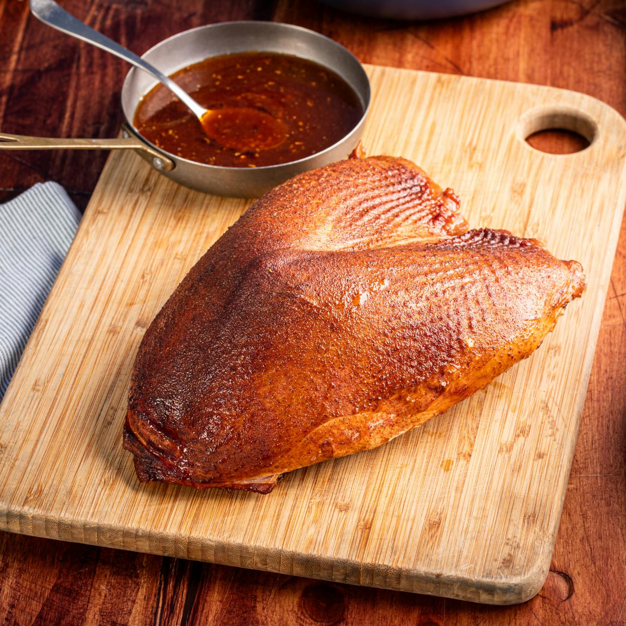 Gorgeous turkey breast on a cutting board and sauce dish in background