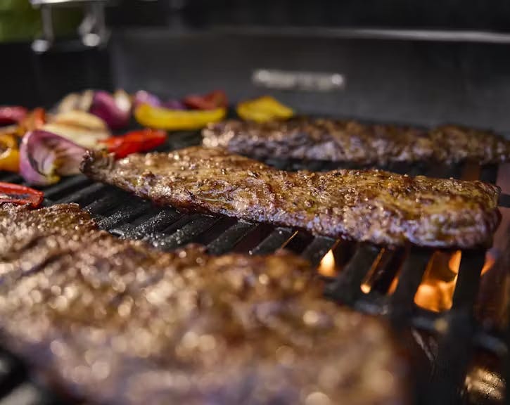 Fajita steak being seared on a grill looking delicious